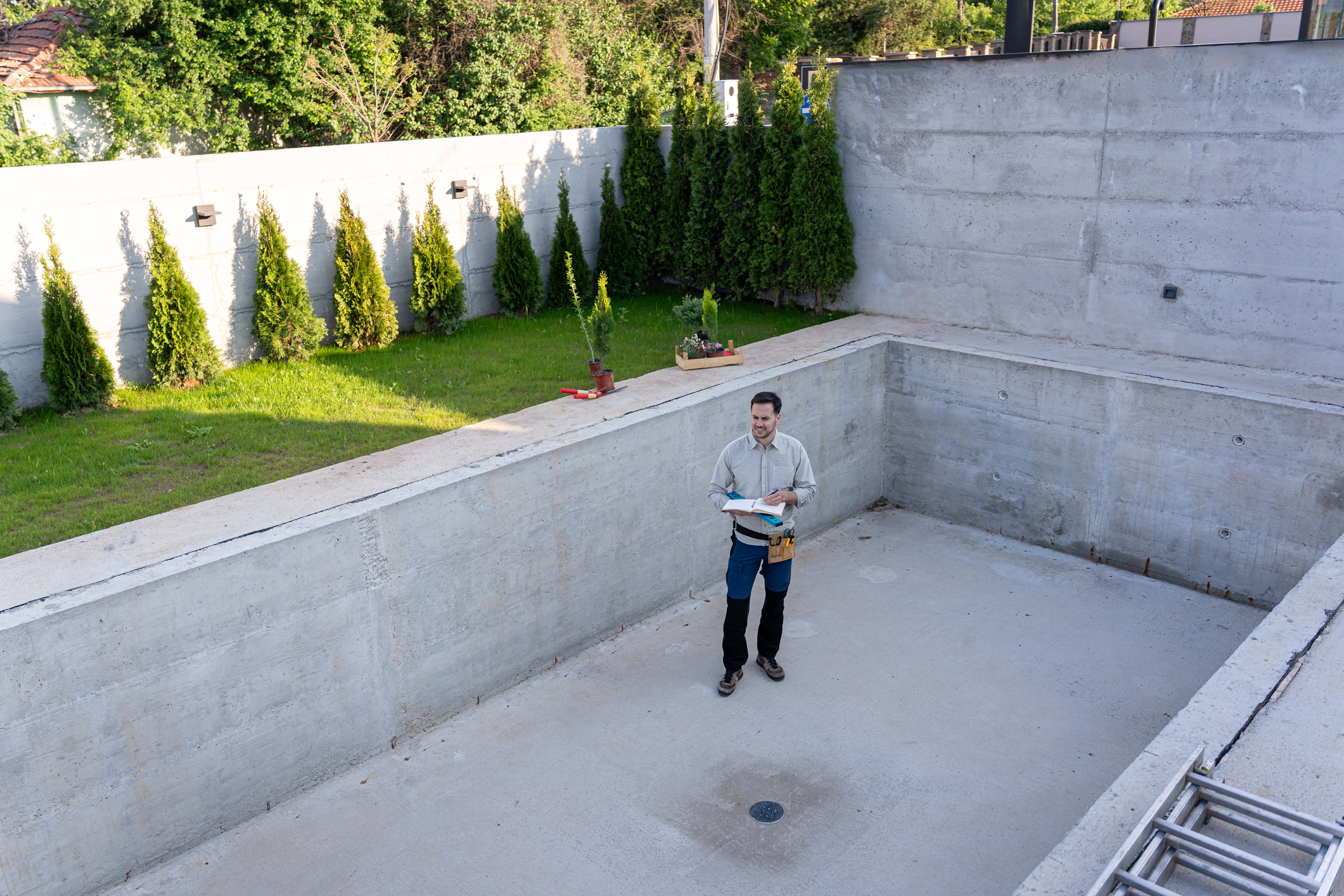 Master engineer inspecting the construction of a luxurious yard and swimming pool